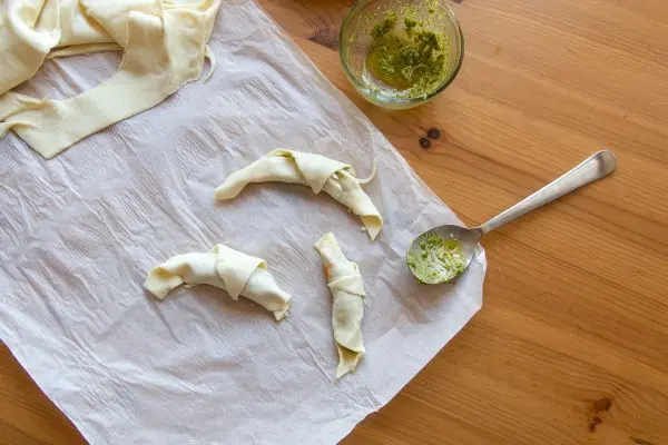 Die Reste des Blätterteigs werden natürlich nicht weggeschmissen! Mit Pesto und Käse gefüllt und zu kleinen Croissants geformt, sind sie der ideale kleine Snack.