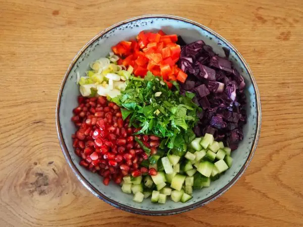 Rotkohl, Granatapfelkerne, Gurke, Paprika, Frühlingszwiebeln und Petersilie sind die Hauptakteure in diesem Wintersalat. 