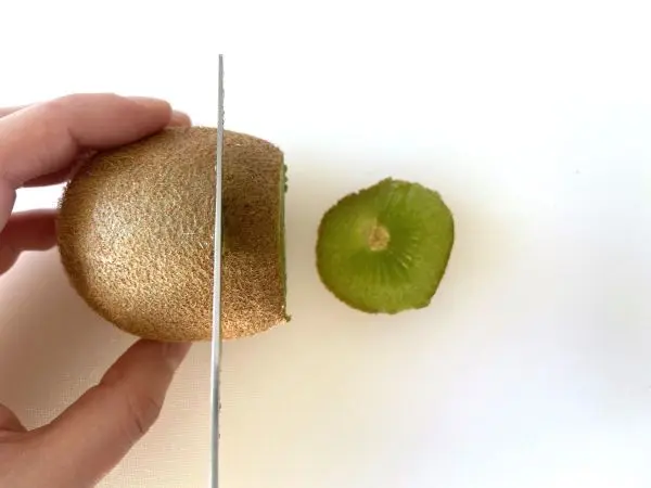 Für die Kiwi-Lollis schneidest du deine Kiwi erst einmal in circa 2 cm dicke Scheiben.