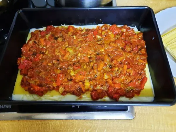 Hier kann man unschwer erkennen, dass soeben eine Lage Tomatengemüsesoße aufgetragen wurde. Hier kann man unschwer erkennen, dass soeben eine Lage Tomatengemüsesoße aufgetragen wurde.