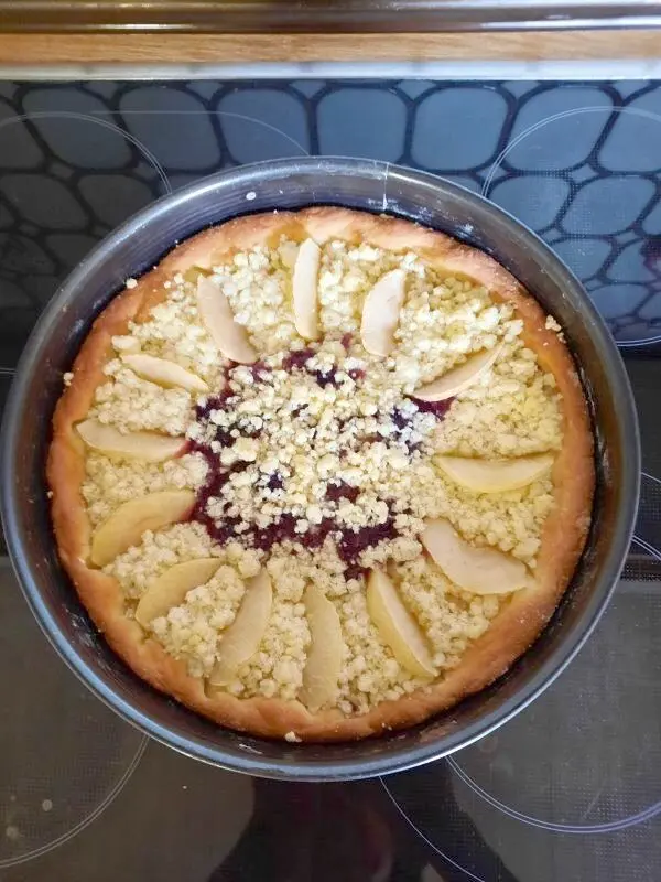 Der Apfelkuchen mit Heidelbeeren und Streuseln kommt fertig gebacken aus dem Ofen. Ein herrlicher Duft schwebt in der Küche.