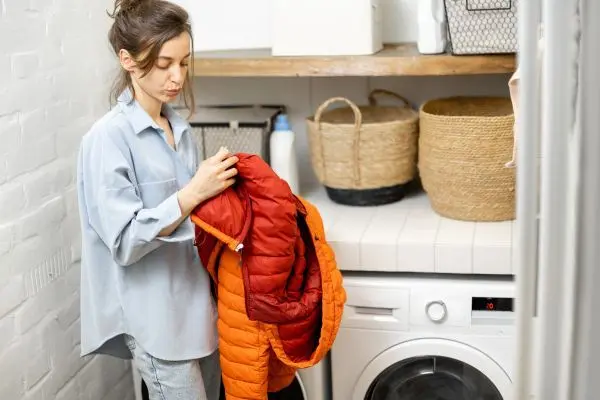 Bevor du deine Daunenjacke reinigen kannst, solltest du alle Reißverschlüsse schließen, Taschen leeren und sie auf links drehen.