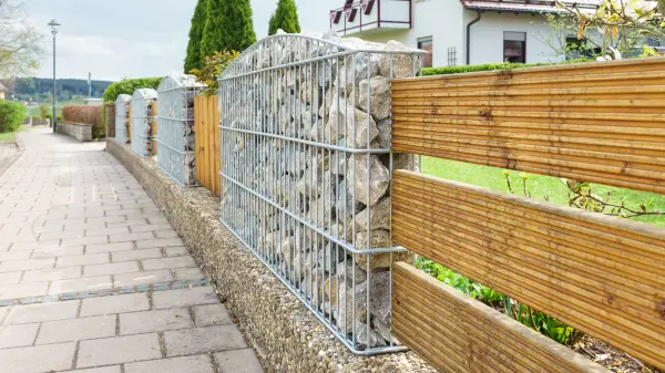 Beim Bau eines Zauns gibt es schier unendlich viele Möglichkeiten: Wie wäre es zum Beispiel mit einer Mischung aus Gabione und Holzzaun?