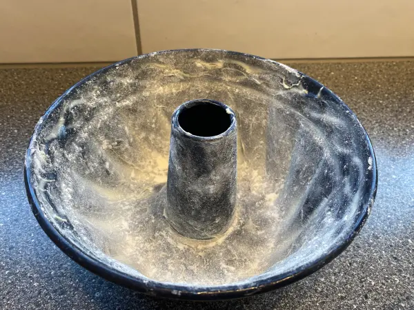 Danach die Backform mit Mehl einstäuben. So löst sich dein Kuchen nach dem Backen leichter und bleibt nicht hängen.