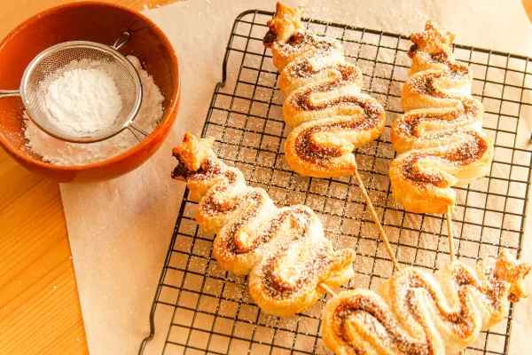Blätterteig-Tannenbäume am Spieß: Mit etwas Puderzucker werden deine Bäume noch winterlicher. Blätterteig-Tannenbäume am Spieß: So einfach zauberst du süße und herzhafte Leckereien für die Adventszeit selbst.
