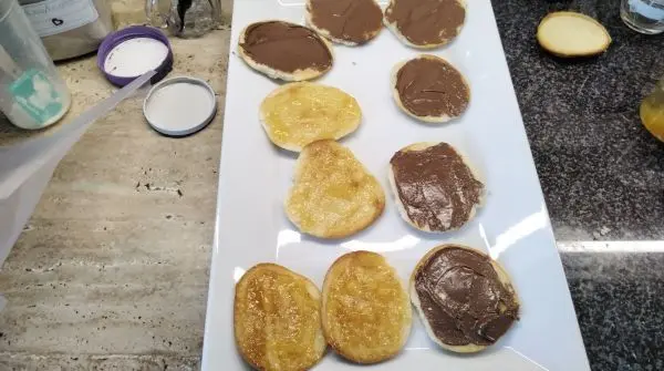 Mit Nutella oder Marmelade die Flächen bestreichen und die Paradiescreme mit einem Beutel aufspritzen.