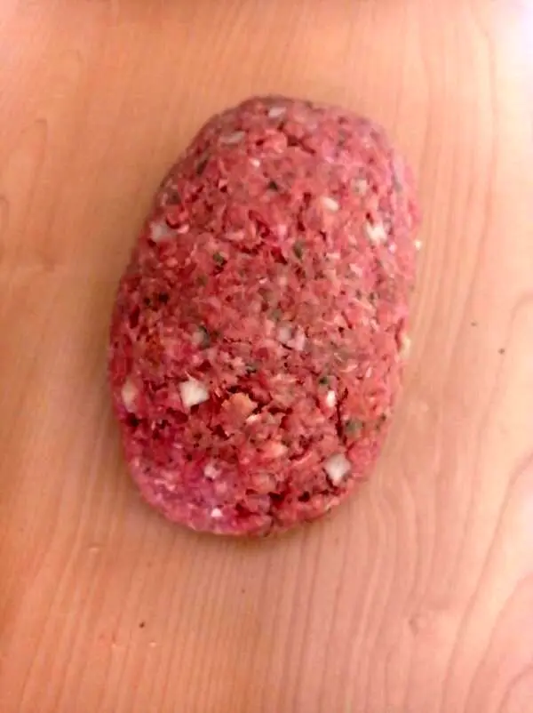 Das Hackfleisch wird jetzt um die Eier geformt und dann wird die Rolle in Butterschmalz angebraten.