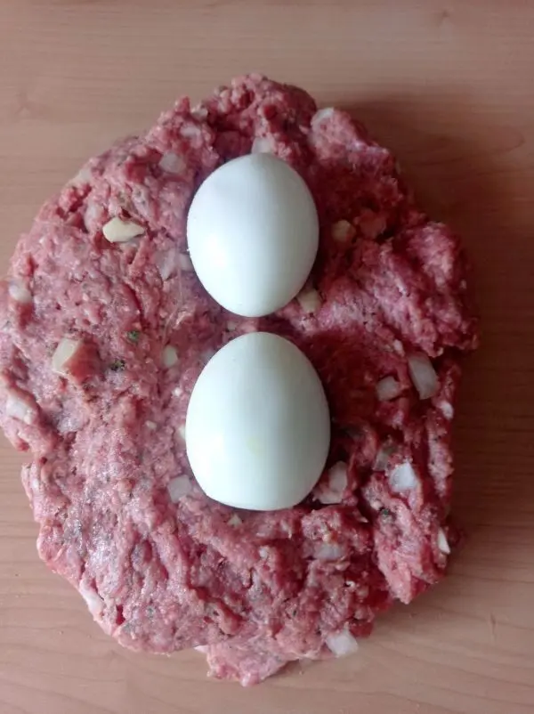 Das Hackfleisch wird mit den Zutaten gemischt und die beiden hart gekochten Eier werden in die Masse gewickelt.