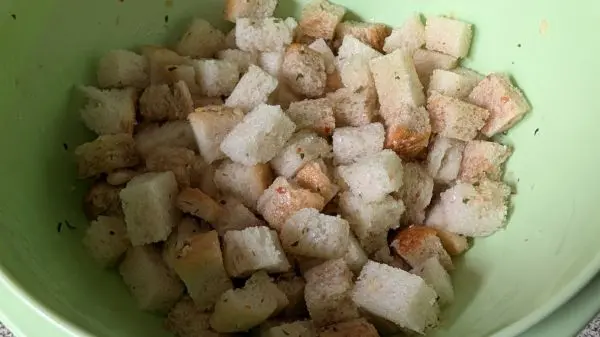 Für die Croûtons werden Toastbrotwürfel, Speckwürfel, Knoblauch- und Basilikumöl sowie Salz und Nuss-Creme gemischt.