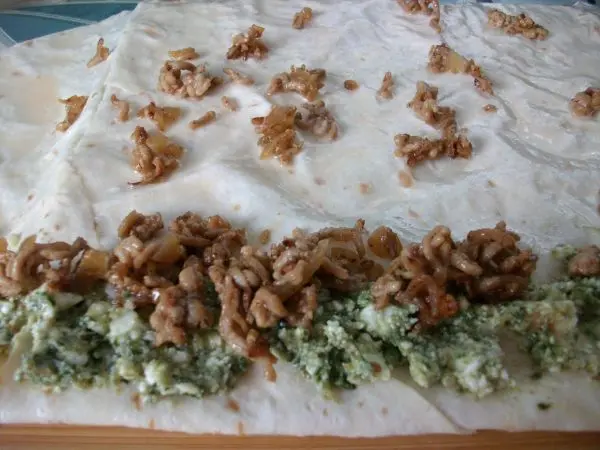 Nun nacheinander Hack-Zwiebel-Mix und Möhrengrün-Feta-Mix auf den schmalen Umschlag aufstreichen.