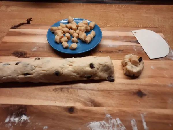 Ich formte aus dem Teig für das Konfekt eine lange Rolle und schnitt davon Stücke ab.