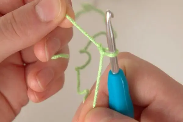Nun müssen wir an beiden Enden festziehen, damit die Schlaufe eng an der Häkelnadel liegt.