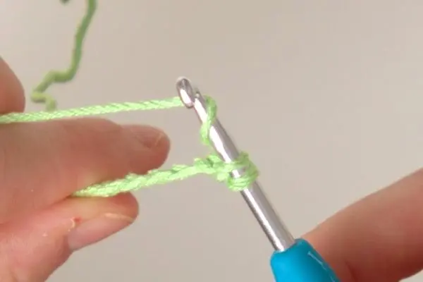 Dann greifst du mit deiner Häkelnadel erneut den Faden und ziehst ihn durch beide Schlaufen auf der Nadel.