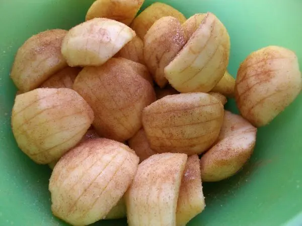 Dann werden die geviertelten Äpfel, jeder einzelne, an der breiten Oberseite längs eingeschnitten und in Zucker & Zimt gewendet.