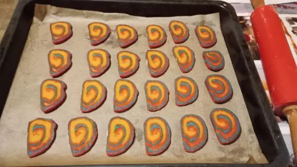 Auf ein Backblech lege ich meine Regenbogen-Plätzchen, die einfach mit einem Messer von der Rolle abgeschnitten werden.