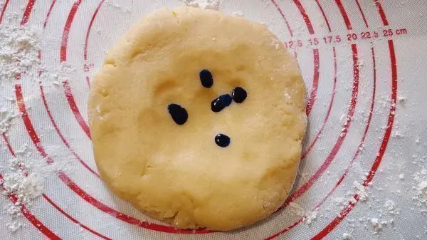 Ich nehme mir die blaue Lebensmittelfarbe zur Hand und träufle 20 Tropfen auf eines der Mürbeteig-Stücke.