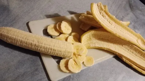 Die Bananen werden geschält, in Scheiben geschnitten und kommen in die Glasschüssel dazu. Die Bananen werden geschält, in Scheiben geschnitten und kommen in die Glasschüssel dazu.