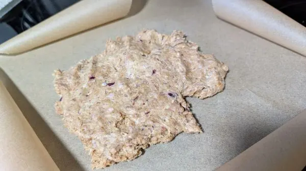 Das Hackfleisch gibt man mittig auf ein Backpapier und drückt es flach an.