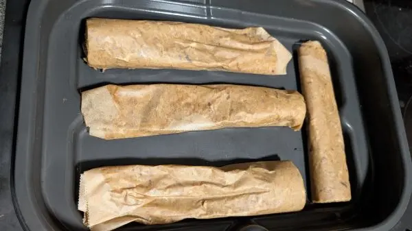 Danach entfernt man das obere Backpapier und rollt das Fleisch zusammen. Für meine Schale habe ich jede Rolle einmal halbiert.
