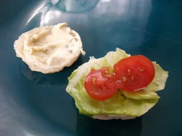 Ich habe auf den unteren und den oberen Teil Kräuter-Frischkäse aufgestrichen und den unteren Teil mit Salat und Tomate belegt.