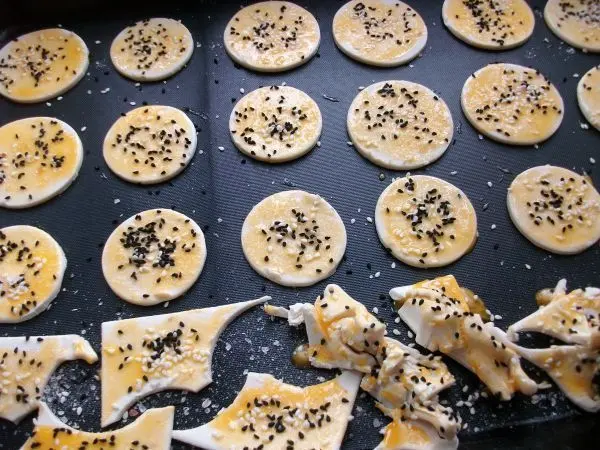 Aus drei Packungen Blätterteig hatte ich insgesamt 18 Teilchen ausgestochen. Das Topping habe ich mit Eigelb, Schwarzümmelsamen und Sesam gemacht.