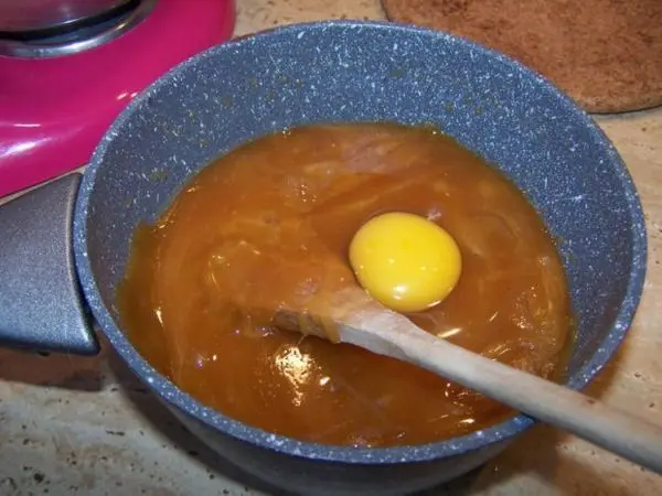 In die ausgekühlte Masse von Honig, braunem Zucker und Butter wird ein ganzes Ei eingerührt. In die ausgekühlte Masse von Honig, braunem Zucker und Butter wird ein ganzes Ei eingerührt.