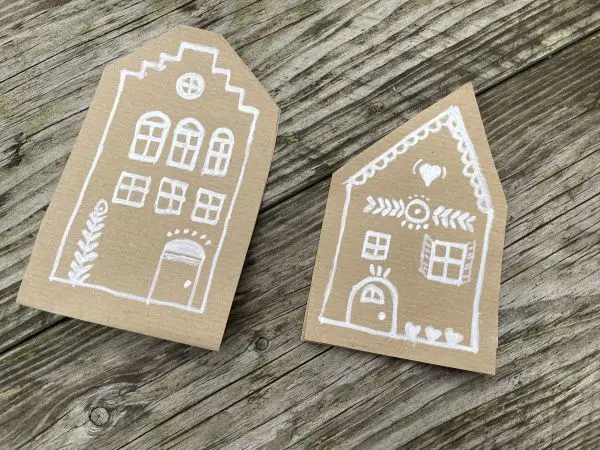 Die aufgezeichneten Lebkuchenhäuser werden aus dem Packpapier mit großzügigem Rand ausgeschnitten.