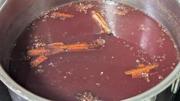 Roter Bratapfellik&ouml;r kochen: Nach dem K&ouml;cheln und Ziehenlassen den Rum zuf&uuml;gen und umr&uuml;hren.