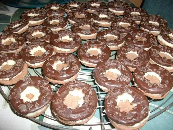 Sind die Teile mit Schokolade getrocknet, wird auf den unteren Teil ein &auml;u&szlig;erer Kreis der Creme aufgespritzt. Dann kommt der Schokodeckel drauf.