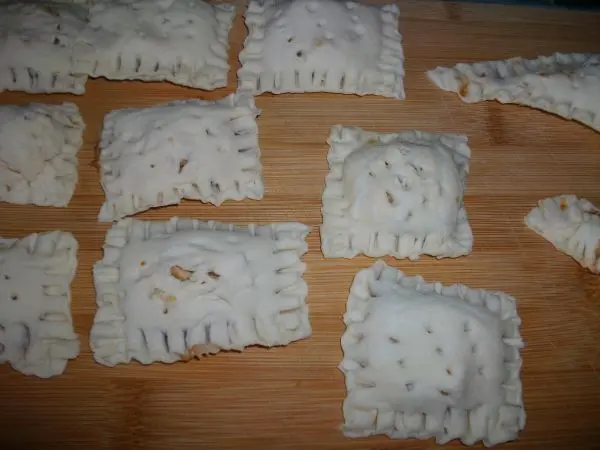 Dann wird die H&auml;lfte des Teigteilchens &uuml;ber die H&auml;lfte mit der F&uuml;llung geklappt. Die R&auml;nder werden mit der Gabel zusammengedr&uuml;ckt.