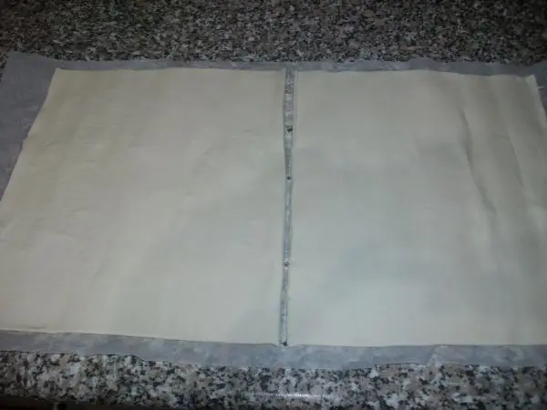 Blätterteig aus der Frischetheke auf der Arbeitsplatte ausrollen und in zwei gleich große Teile schneiden. Blätterteig aus der Frischetheke auf der Arbeitsplatte ausrollen und in zwei gleich große Teile schneiden.