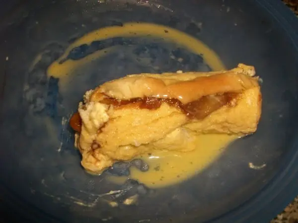 Jetzt wird die gef&uuml;llte Toastrolle in dem mit Milch verquirlten Ei gewendet und sofort mit Butter goldgelb angebraten.