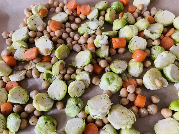 Rosenkohl, Kichererbsen und M&ouml;hren werden auf einem Backblech ausgelegt und im Backofen ger&ouml;stet.