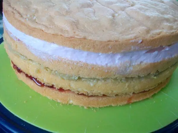 Den dritten Bisquit aufschichten, wieder mit Amaretto tr&auml;nken und die Amarena Paradiescreme aufstreichen.