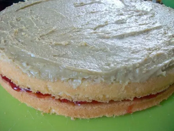 Einen weiteren Tortenboden aufschichten, erneut mit Amaretto tr&auml;nken und dann die Pistaziencreme aufstreichen.