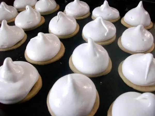 Die steif geschlagene Baisermasse &uuml;ber die die Minit&ouml;rtchen (Busserl) mit Schokoladenf&uuml;llung aufspritzen.