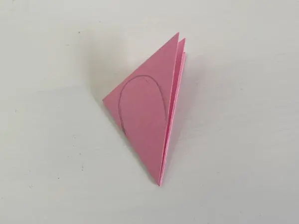 Auf die Faltung zeichnest du ein Rosenblatt auf und schneidest es aus, sowie die untere Spitze ab.