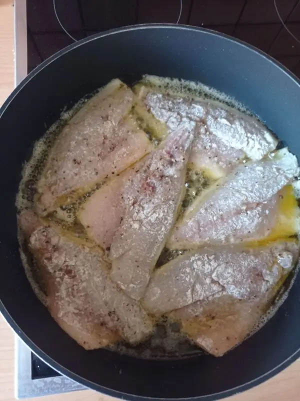 Die Doradenfilets werden mit Pfeffer und Salz gew&uuml;rzt und in Mehl gew&auml;lzt, bevor sie im hei&szlig;en Fett gebraten werden.
