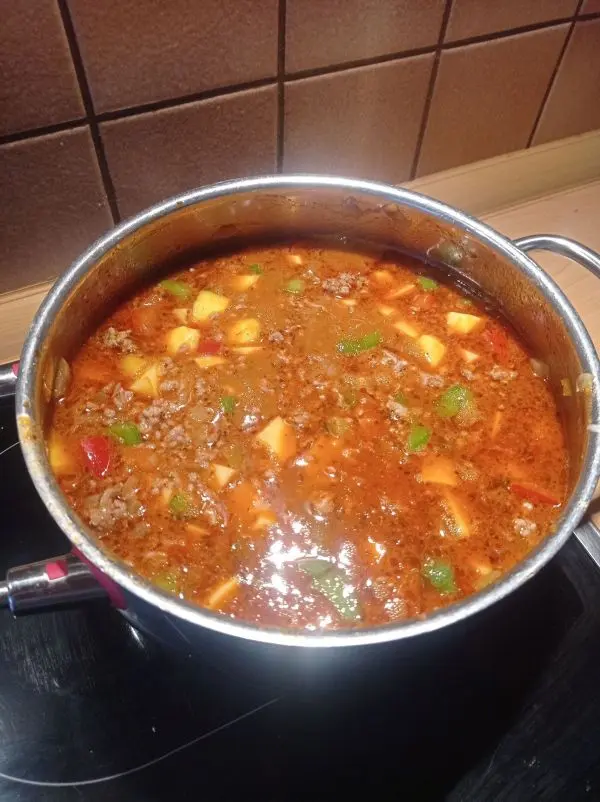 Die Br&uuml;he wird nun portionsweise zugegossen, damit der Puszta-Topf nicht zu d&uuml;nnfl&uuml;ssig wird.