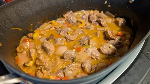 Mit gutem Fond & Rotwein abl&ouml;schen. Das Ganze mit Bratenpaste, Fleisch und Knochen schmoren lassen.