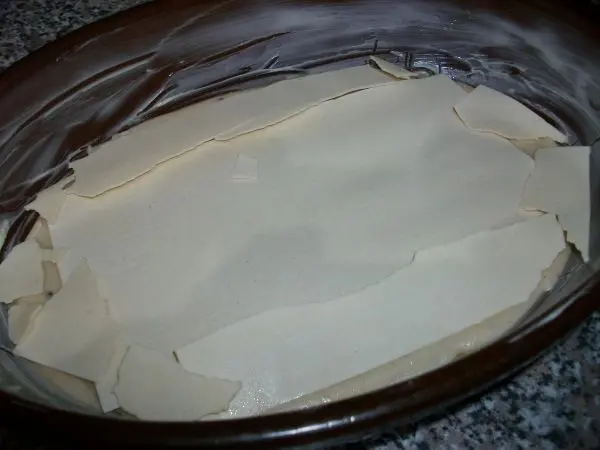 Dann kommt die erste Schicht Lasagne Nudelteigblätter auf die Béchamelsoße. Man kann die Blätter brechen oder zuschneiden. Dann kommt die erste Schicht Lasagne Nudelteigblätter auf die Béchamelsoße. Man kann die Blätter brechen oder zuschneiden.