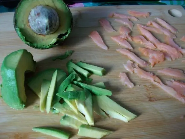 Die halbe Avocado in kleine St&uuml;cke schneiden und die Lachsscheibe ebenso in kleine St&uuml;cke vorbereiten.