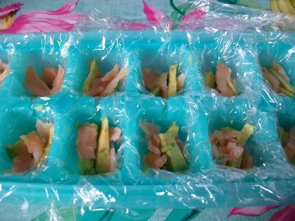Jetzt gibt man in jedes Eisw&uuml;rfelfach etwas vom Lachs und auch noch etwas von den Avocadost&uuml;cken.