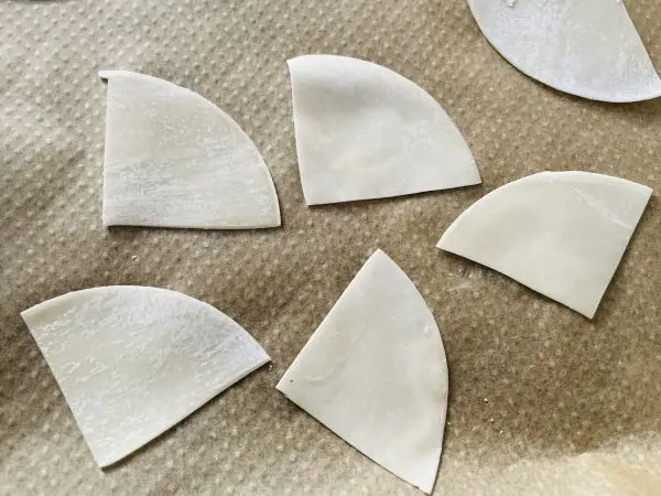 Vor dem Backen der Gyoza Chips kann man die Teigblätter vierteln. Vor dem Backen der Gyoza Chips kann man die Teigblätter vierteln.