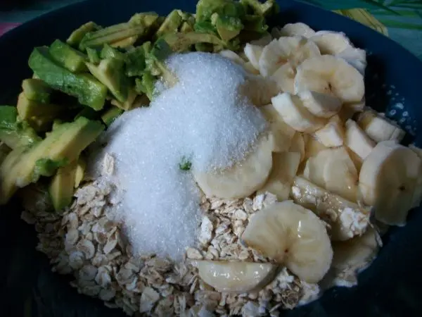 In mein M&uuml;sli kommen Haferflocken, kleingeschnittene Avocado, halbierte Bananenscheiben und Zucker.
