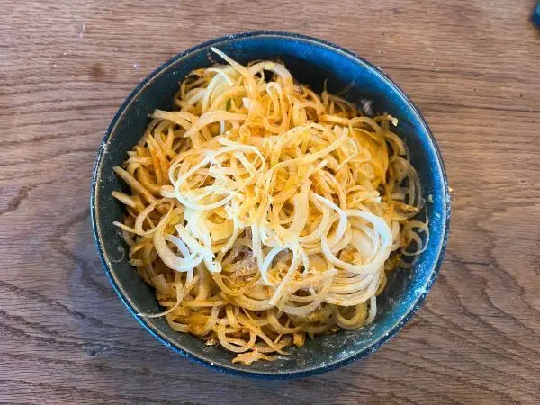 Je feiner die Zwiebelringe, desto knuspriger werden die R&ouml;stzwiebeln. Im Anschluss werden sie mit Mehl und Paprikapulver vermengt.