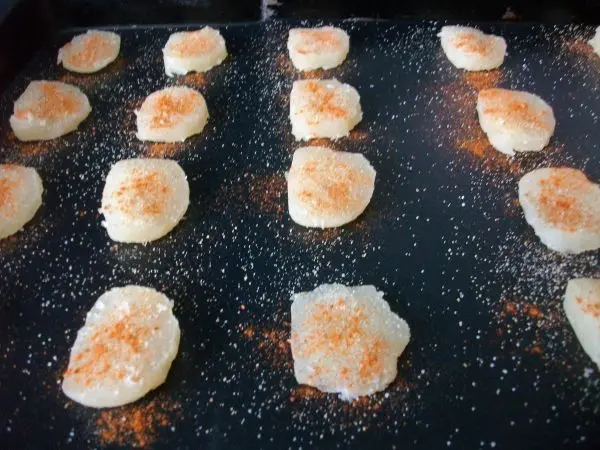 Dann werden die K&auml;sescheiben mit etwas Salz, Knoblauchpulver und Pfeffer bestreut. Gew&uuml;rze gerne auch nach eigenem Geschmack.