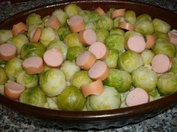 Dann schneide ich die Saiten (auch Wiener W&uuml;rstchen genannt) in kleine Scheiben und verteile sie ebenfalls auf dem Auflauf.