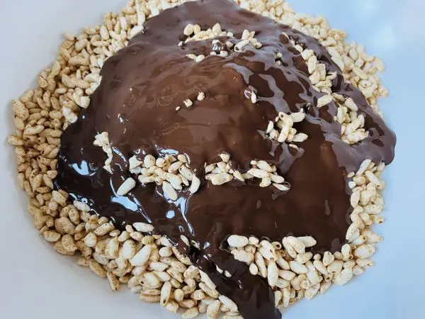 Der Vollkorn-Puffreis wird mit geschmolzener Schokolade vermischt.