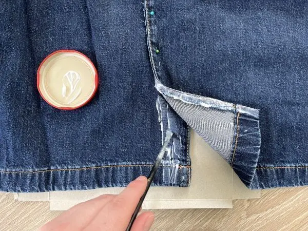 Dann klebst du deine alte Jeans nach und nach mit Textilkleber zu einem Rock zusammen.